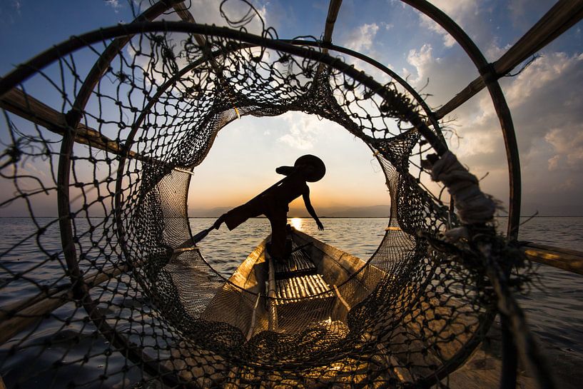 Pêcheur avec bateau traditionnel sur le lac Inle au Myanmar essaye d'attrapper un poisson avec un pa par Wout Kok