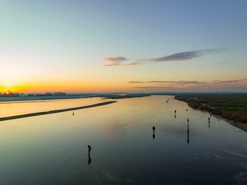 Ice skating on a lake during a beautiful winter sunset by Sjoerd van der Wal Photography