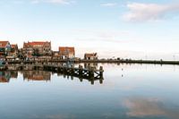 Vue avec réflexion sur la digue et la jetée à Volendam