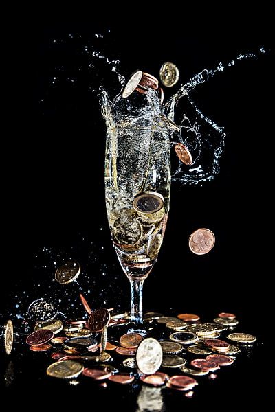 Money coins fall into a champagne glass against a black background by Hans-Jürgen Janda